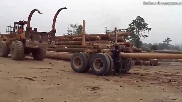 Процесс установки и разборки лесозаготовительного грузовика с прицепом с помощью колесного погрузчик