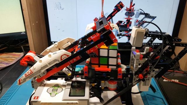 Робот Лего собирает кубик рубика