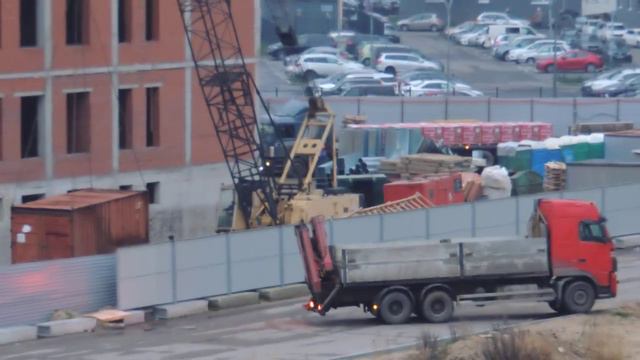 Самоходный кран выгружает контейнер из крана манипулятора Volvo