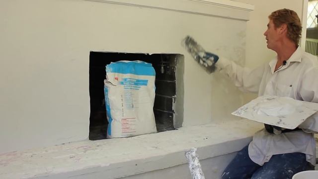 Lime plastering over an interior fireplace.