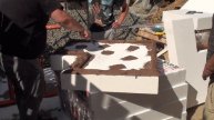 Нанесение клея на лист пенопласта и приклейка первого листа на кривой фасад дома