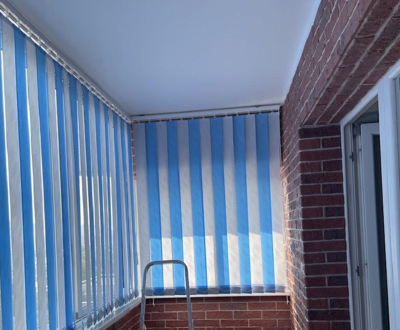 Жалюзи Вертикальные на балкон с чередованием полос в ткани Битиф небесного голубого и белого оттенка