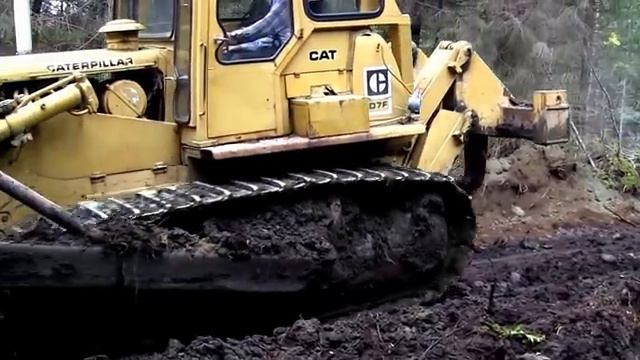 Бульдозер Caterpillar D7 F расчищает лесную дорогу