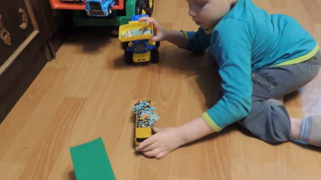 Малыш играет с рабочими машинками дома