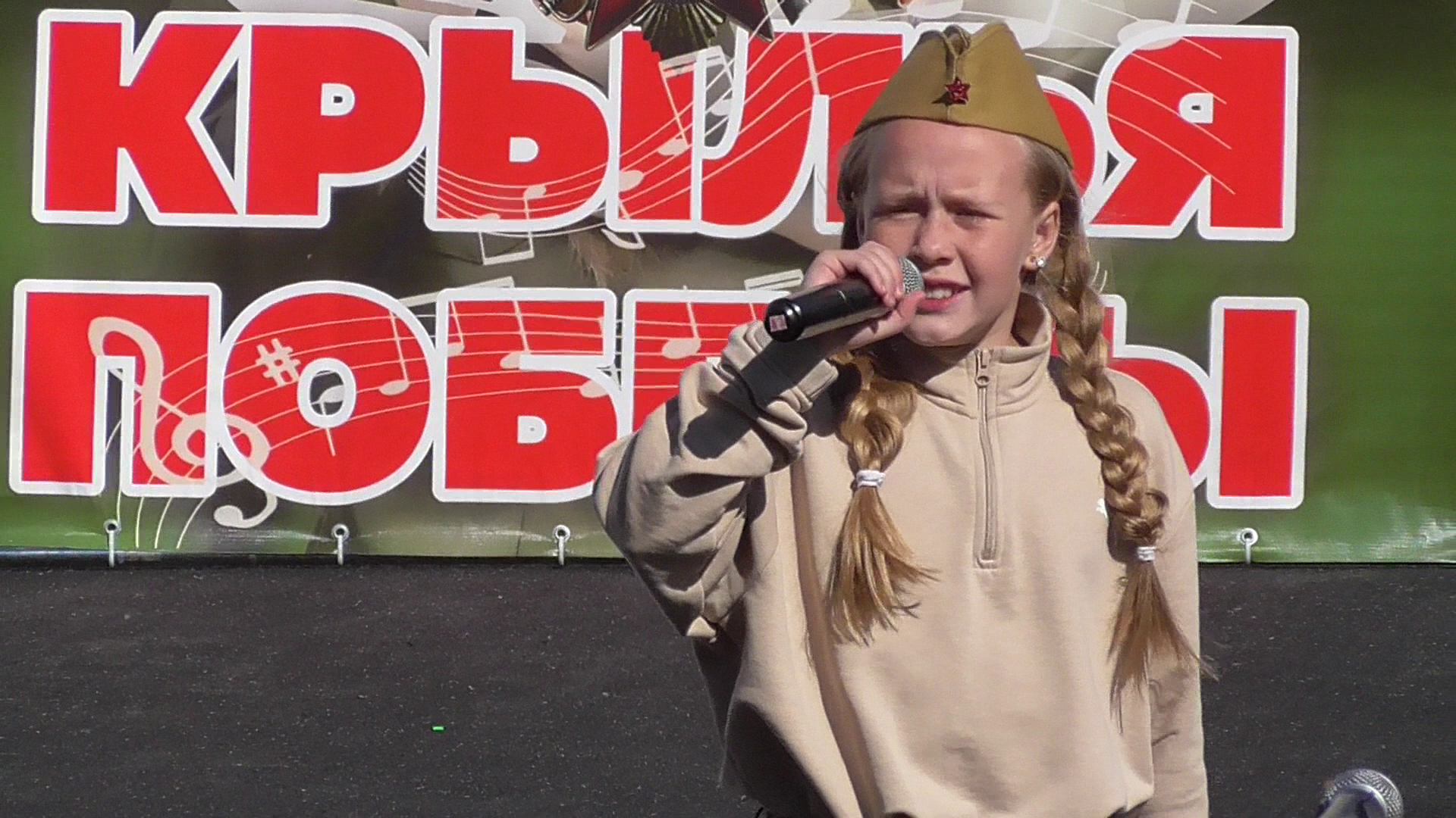 Девушка на празднике Крылья Победы поёт песню, песня: Мы