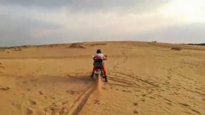 Груженный "Баджадж Боксер 125" идёт на подъём в глубоком песке.