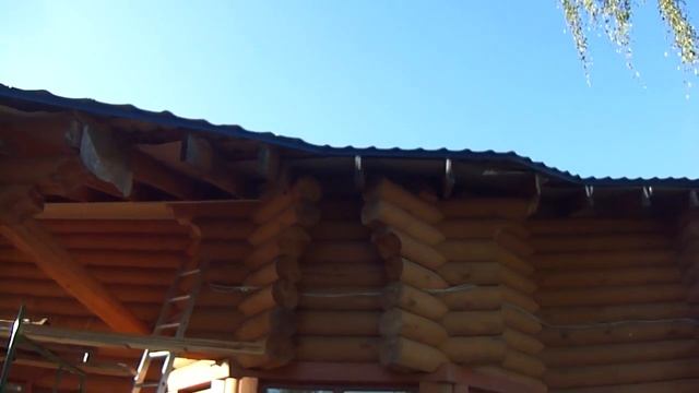 Подшивка свеса крыши дома из оцилиндрованного бревна.