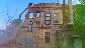 Снос производственного здания длинноруким экскаватором