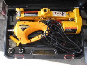 Электрический 12 вольтовый домкрат помогает заменить колесо автомобиля