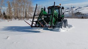 Трактор с гусеничным ходом преодолевает снег