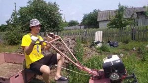 Гоняет на мотоблоке по полю в деревне. Чуть не поломался. Возит дрова в опасном месте