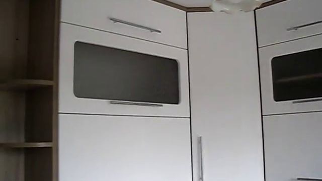 Угловой кухонный гарнитур с встроенной вытяжкой.