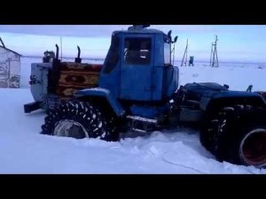 Т150К на спарках.разбиваем твердый снег возле склада.