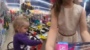 Амелька в магазине игрушек выбирает подарок на Новый год.