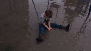 Ребёнок купается в луже