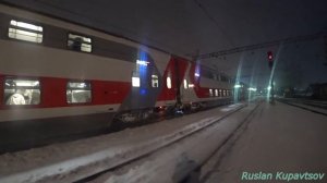 ЭП20-063 прибывает с двухэтажным поездом на станцию Мурманск в полярную зимнюю ночь в снегопад .