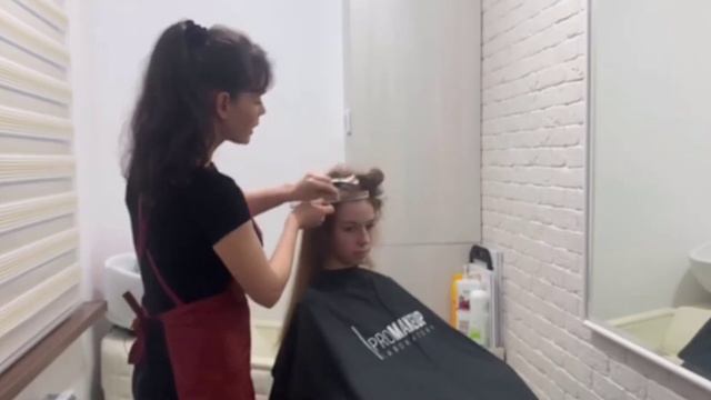 Выполнение горячей укладки волос с помощью электрощипцов