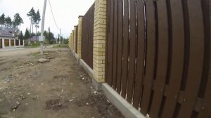 Деревянный забор с кирпичными столбами