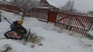 Уборка снега мотоблоком на гусеницах. Snow removal with a walk-behind tractor on tracks.