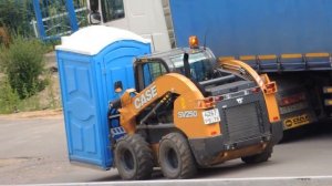 Мини погрузчик перевозит биотуалет