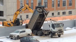 Экскаватор помогает Самосвалу выгрузить песок.