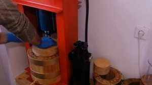 Отжим кокосового масла  в деревянном бочонке.
