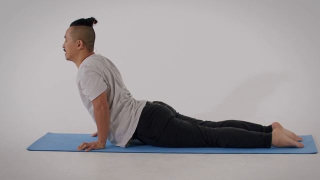 человек выполняет позу кобра в йоге, вид сбоку