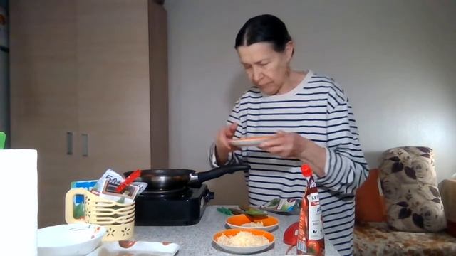 Тушу минтай в кетчупе с помидорами, чесноком и тертым сыром в сковороде. Тельняшка от сына