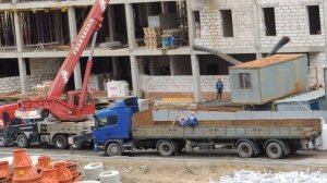 Автокран разгружает шаланду длинномера Скания