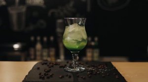 a close up of fresh mojito on a bar counter with coffee beans