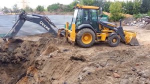 Экскаватор погрузчик John Deere в работе