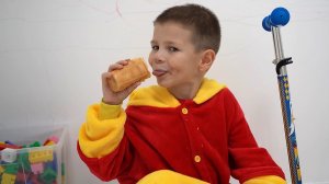 Ребенок ест шоколадный пончик и вкусное мороженое с цветными конфетами.