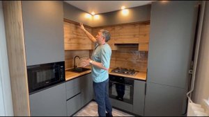 Угловая кухня с двумя пеналами, антресолями и встроенной стиральной машиной в стиле минимализм.