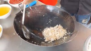 Жареная лапша на большой железной тарелке, жареный рис с креветками, жареная лапша