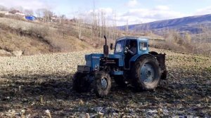Трактор Т-40 с прицепом буксует на мокрой дороге.Трактор в сельском хозяйстве!
