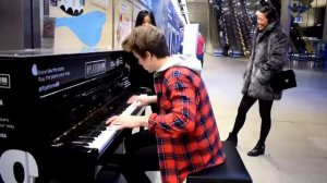 Парень очень талантливо играет на пианино в общественном месте.