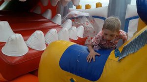 Дети играют в детском центре, катаются на лошади. Развлечение для детей.