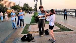 Скрипачи на набережной Волги исполняют красивую классическую музыку.Уличные музыканты