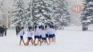 Девочки маршируют в коротких юбках под снегом