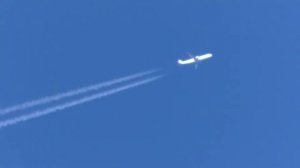 Еще один летит самолет, оставляя за собой след в небе.