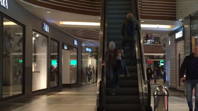 Женщина с ребёнком спускается вниз по эскалатору, который движется вверх смотреть онлайн