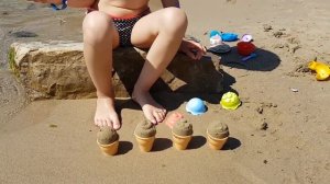 Kids playing on the beach . They making ice cream and cakes from sand. Video 2016