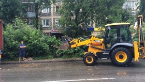 Экскаватор-погрузчик разгружает фуру полетными вилами в Калуге