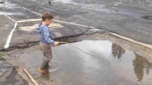 Малыш ловит рыбу в луже