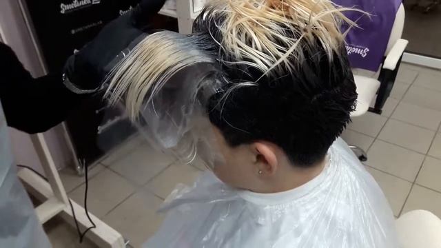 девушка в салоне с фольгой или пленкой на волосах ожидает процедуру