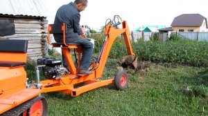 На фаркопе минитрактора - прицепной экскаватор