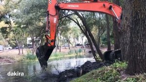 Экскаватор хитачи расчищает озеро