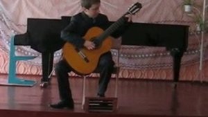 маленький мальчик, играет на гитаре