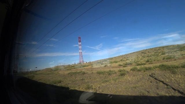Вышка на горке из окна поезда недалеко от станции Карабас (Қарабас) летом 2021 года