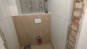 Укладка плитки в туалете и ванной. Запилы углов под 45. Два лючка на магнитах в коробе.